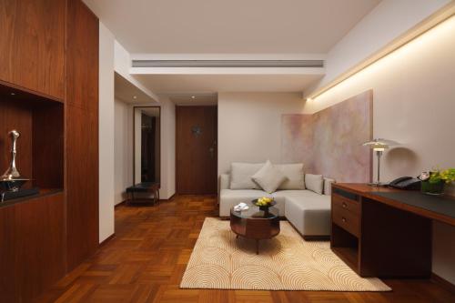 a living room with a couch and a table at Maxx by Steigenberger on the Bund Shanghai in Shanghai