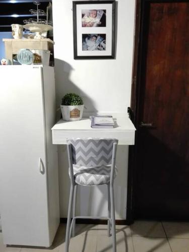 una scrivania bianca con sedia accanto a un frigorifero di El Refugio al Norte del Fin del Mundo a Río Grande