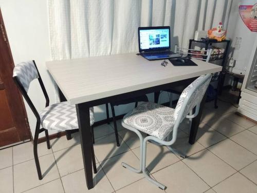 里奧格蘭德的住宿－El Refugio al Norte del Fin del Mundo，一张桌子,上面有一台笔记本电脑和两把椅子