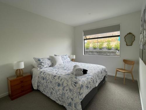 a bedroom with a bed and a window at Lake Views - new apartment with room to relax in Wanaka