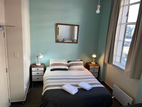 a bedroom with two beds and a mirror on the wall at UpTown Backpackers in Dunedin