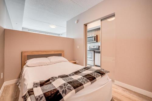 um quarto com uma cama com um cobertor xadrez em 1 Bedroom Condo in Waterloo em Waterloo