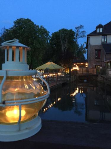 a lit up fire hydrant in front of a pond at Logis - Hôtel & Restaurant Moulin Des Forges in Saint-Omer-en-Chaussée