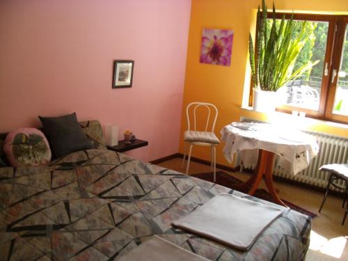 Schlafzimmer mit einem Bett, einem Tisch und einem Fenster in der Unterkunft Tannhäuser b&b in Bad Dürrheim