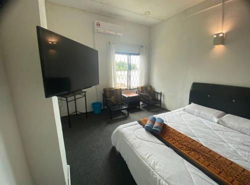a bedroom with a bed and a flat screen tv at SB SUNSET KUCHING in Kuching