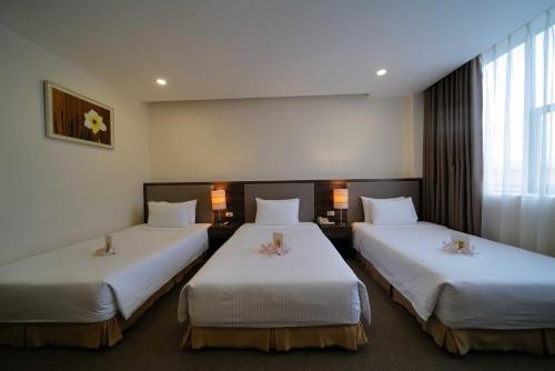 a hotel room with two beds with flowers on them at Mường Thanh Grand Dien Bien Phu Hotel in Diện Biên Phủ
