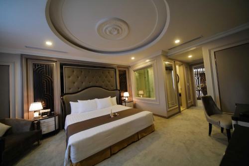 een slaapkamer met een groot bed en een bank bij Mường Thanh Grand Dien Bien Phu Hotel in Diện Biên Phủ