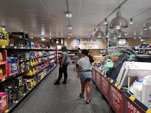 two women are walking through a grocery store aisle at Sydney Olympic Park Half House - All Yours in Sydney