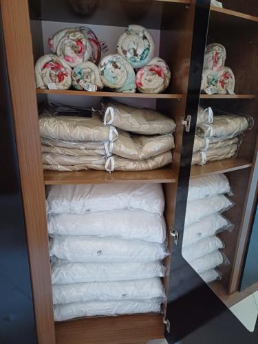 a closet filled with towels and plates on shelves at Apto em Marataízes-ES, 03 quartos e 02 banheiros in Marataizes