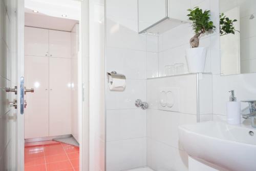 a white bathroom with a shower and a sink at Amanda Apartment in Zagreb