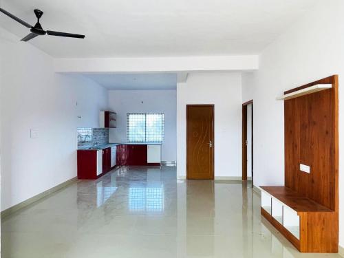 a living room with white walls and a ceiling fan at Dhruva Service Apartment in Bidadi