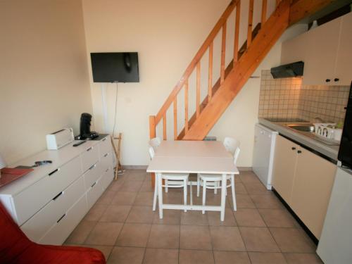 - une cuisine avec une table blanche et des chaises blanches dans l'établissement Studio cosy avec terrasse à 250m de la plage - FR-1-22-342, à La Tranche-sur-Mer