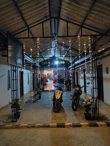 two motorcycles parked inside of a building with lights at Hotel Ariza Real in Saravena