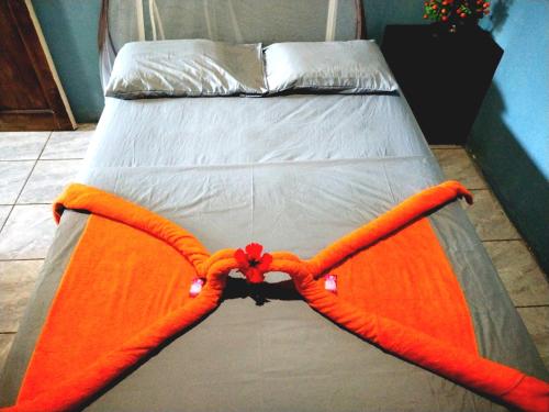 pomarańczowa kołdra na łóżku w pokoju w obiekcie Anluka-House w mieście Puerto Jiménez