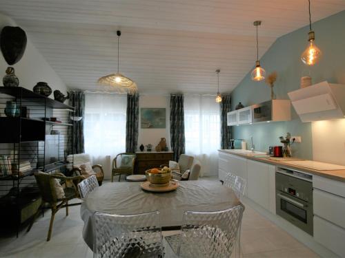 une cuisine et un salon avec une table et des chaises dans l'établissement Maison rénovée à La Tranche-sur-Mer, proche plages et commerces, pour 4 personnes - FR-1-22-300, à La Tranche-sur-Mer
