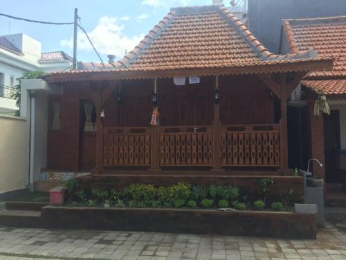 Casa con porche de madera con valla en Bharata Beach House, en Keramas