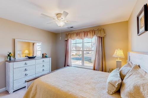 een slaapkamer met een bed, een dressoir en een raam bij Millville by the Sea --- 33504 Belvedere St in Millville