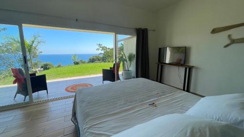 a bedroom with a bed and a large window at Casitas Sollevante Boutique Hotel in Montezuma