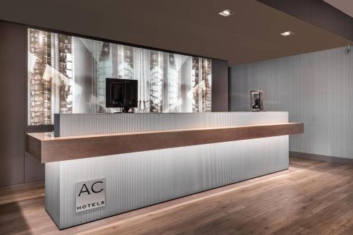 an office lobby with a reception desk with a tv on the wall at AC Hotel by Marriott Alicante in Alicante