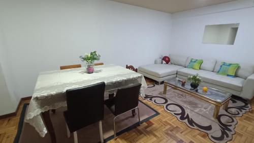 uma sala de estar com uma mesa e um sofá em Acogedor y Céntrico Depto Av. Libertador Cala Cala em Cochabamba