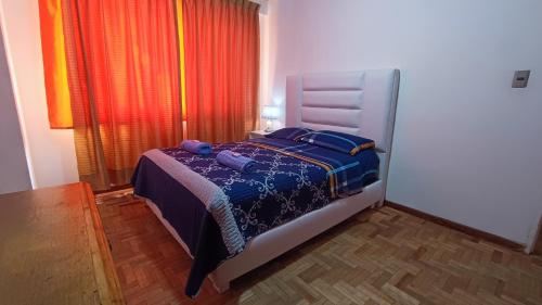 a bedroom with a bed in a room with a window at Acogedor y Céntrico Depto Av. Libertador Cala Cala in Cochabamba