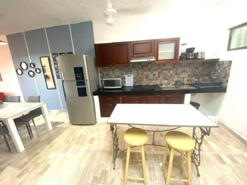 a kitchen with a table and two chairs and a refrigerator at Villa Caribe Cancún in Cancún