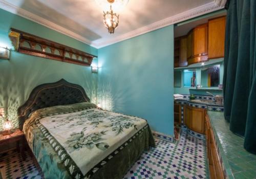a bedroom with a king sized bed and a kitchen at Riad Scalia Traditional Guesthouse Fes Morocco in Fès