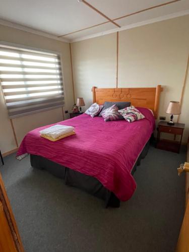 a bedroom with a large bed with a red blanket at Cabañas Porvenir Tierra del Fuego in Porvenir