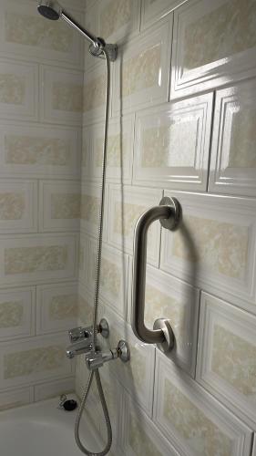 una ducha con una manguera pegada a la pared en Cabañas Porvenir Tierra del Fuego en Porvenir