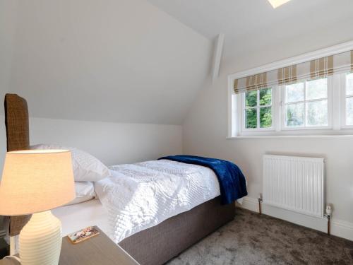 a bedroom with a bed and a lamp and a window at 3 Bed in Kiplin 79275 in Great Langton