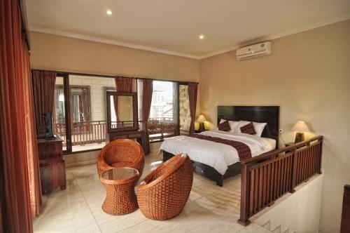 una camera con un letto e due sedie in vimini di Leo Villa ad Ubud