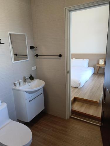 a bathroom with a toilet a sink and a bed at 日日和 in Tainan