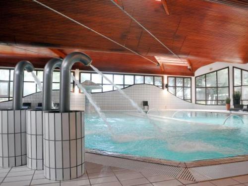 une grande piscine avec une fontaine dans l'établissement Maison Familiale avec Jardin, Proche Mer et Commerces - Saint Jean de Monts - FR-1-323-410, à Saint-Jean-de-Monts