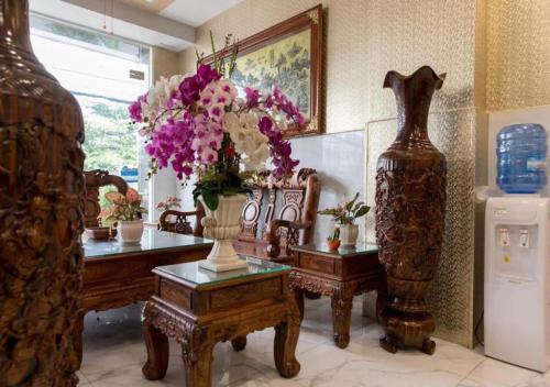 um quarto com um vaso de flores sobre uma mesa em Bro Hotel 45-47 Song Hành, Quận 6 - by Bay Luxury em Ho Chi Minh