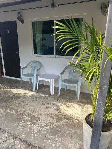 two chairs and a table in front of a house at Jolie’s Place in Ko Lanta
