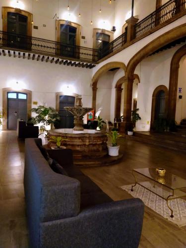 a living room with a couch and a fountain at Markee Hotel Boutique in Querétaro