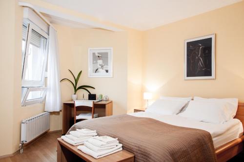 um quarto com uma cama, uma secretária e uma janela em Apartment Avenue em Zagreb