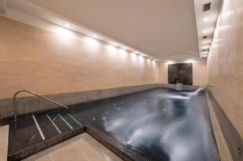 una piscina a corsie in una camera d'albergo con acqua di Áurea Convento Capuchinos by Eurostars Hotel Company a Segovia