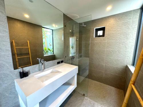 La salle de bains est pourvue d'un lavabo et d'une douche en verre. dans l'établissement Baan Saint-Tropez Seaview Villa Ko Samui., à Bophut 