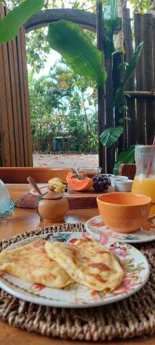 una mesa de madera con platos de comida. en Afeto Caraíva, en Caraíva
