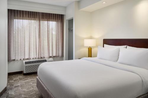 - une chambre avec un grand lit blanc et une fenêtre dans l'établissement SpringHill Suites Richmond Northwest, à Richmond