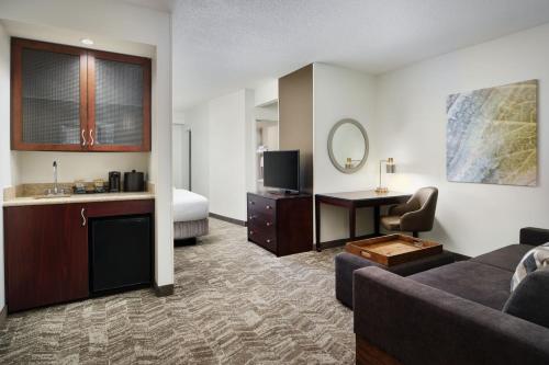 Habitación de hotel con sofá y cama en SpringHill Suites Richmond Northwest, en Richmond