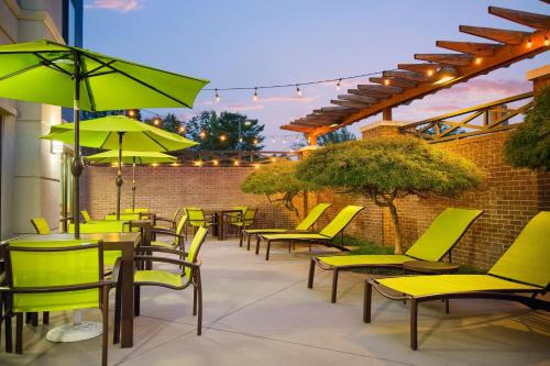 a patio with yellow chairs and tables and umbrellas at SpringHill Suites Richmond Northwest in Richmond