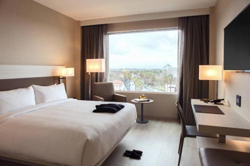 AC Hotel by Marriott San Jose Downtown في سان خوسيه: غرفة فندقية بسرير ونافذة كبيرة