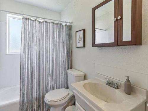 ein Badezimmer mit einem Waschbecken, einem WC und einem Spiegel in der Unterkunft Pickle Ball Courts Close By Quiet Neighborhood in Bountiful