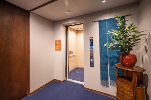 a hallway with a plant in a vase on a table at Shorenkan Yoshinoya in Kyotango