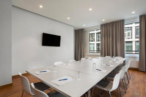 a conference room with a large white table and chairs at Holiday Inn Express Munich City West by IHG in Munich