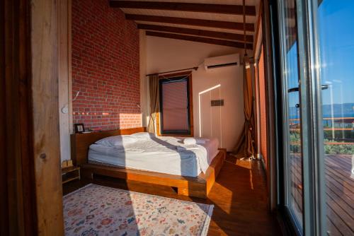 a bedroom with a bed and a large window at Lake360 in Boyalıca