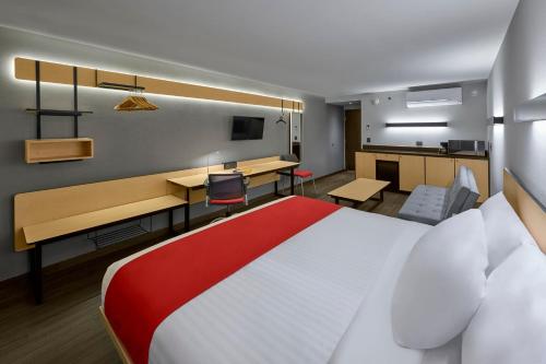 メキシコシティにあるCity Express by Marriott La Razaの大きなベッドとデスクが備わるホテルルームです。