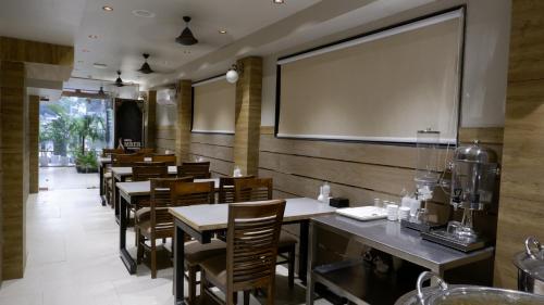a restaurant with tables and chairs and a large screen at Hotel Skylink Hospitality Next to Amber Imperial in Mumbai